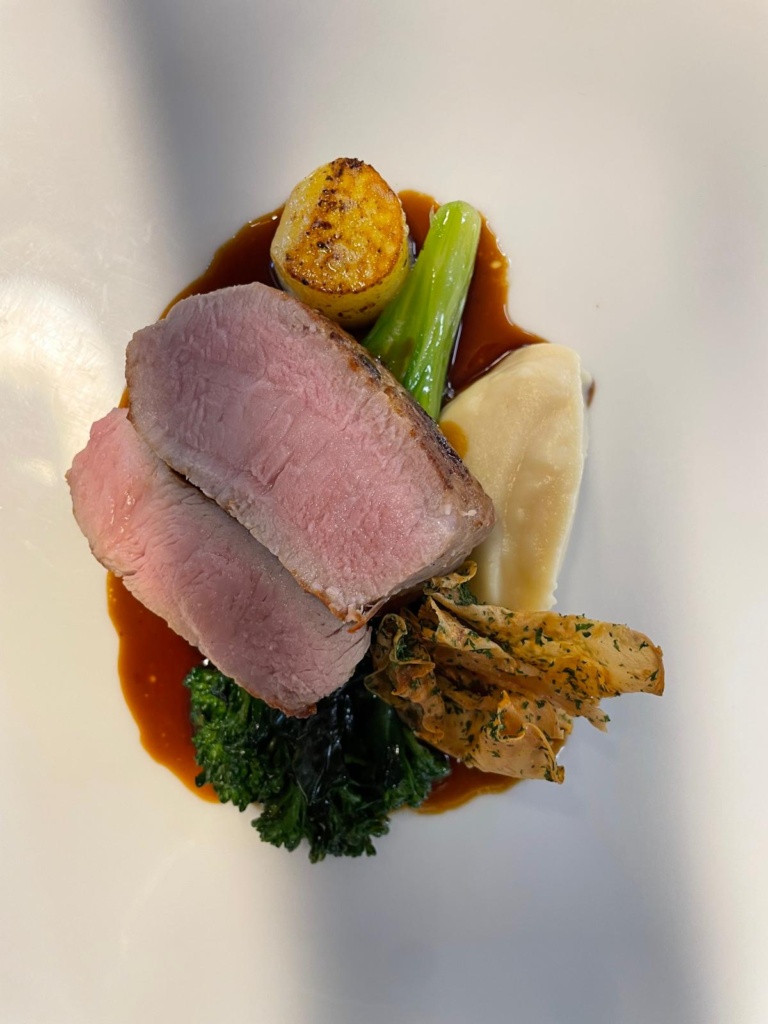 Rosa gebratenes Kalbfleisch mit Jus und Gemüse
